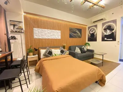 a bedroom with a bed and a couch and a table at Twin Oaks near MRT Shaw, Megamall, Shangri-la plaza in Manila