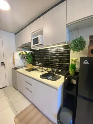 a kitchen with white cabinets and a sink and a microwave at Twin Oaks near MRT Shaw, Megamall, Shangri-la plaza in Manila