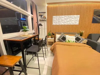 a bedroom with a bed and a table and a table and chairs at Twin Oaks near MRT Shaw, Megamall, Shangri-la plaza in Manila