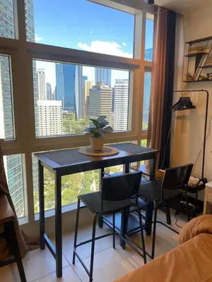 a table and chairs in a room with a large window at Twin Oaks near MRT Shaw, Megamall, Shangri-la plaza in Manila