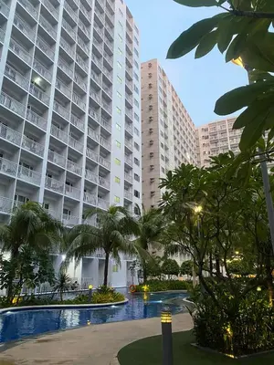 a large building with palm trees in front of it at COZY PASAY CONDOMINIUM HOTEL UNIT with NETFLIX in Manila