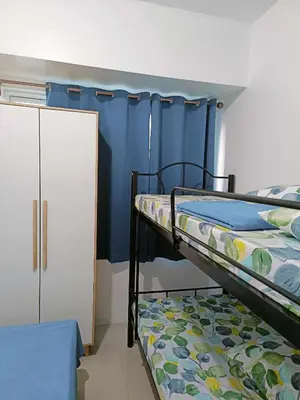 a bedroom with two bunk beds and a blue wall at 2 bedroom just accross MOA and SMX by jam ez in Manila