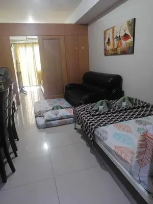 a living room with a bed and a couch at 2 bedroom just accross MOA and SMX by jam ez in Manila