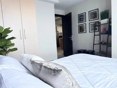 a bedroom with a white bed with pillows on it at City Lights Apartment in BGC in Manila