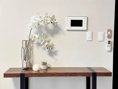 a table with a vase of flowers on a wall at City Lights Apartment in BGC in Manila