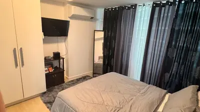 a bedroom with a bed and a tv and curtains at Art & Zen - Azure Staycation in Manila