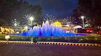 a fountain with blue lights in a park at night at Art & Zen - Azure Staycation in Manila