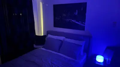 a dark room with a bed and a tv at Art & Zen - Azure Staycation in Manila
