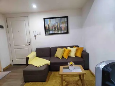 a living room with a couch and a table at Cozy fully furnished 2 BR unit in Manila