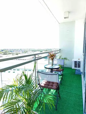 a balcony with chairs and a table and a view of the ocean at Cozy fully furnished 2 BR unit in Manila