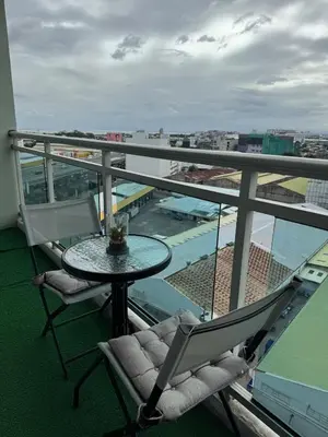 a balcony with a table and chairs and a view of a stadium at Cozy fully furnished 2 BR unit in Manila