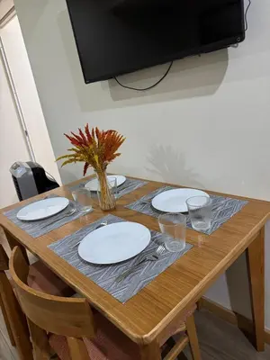a wooden table with plates and utensils on it at Cozy fully furnished 2 BR unit in Manila