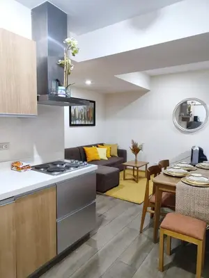 a kitchen and living room with a couch and a table at Cozy fully furnished 2 BR unit in Manila