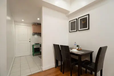 a kitchen and dining room with a table and chairs at Studio Penthouse in Greenbelt - Park View & Pool in Manila