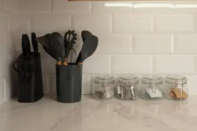 a black container with utensils and jars on a counter at Studio Penthouse in Greenbelt - Park View & Pool in Manila