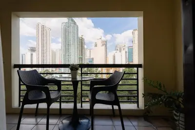 a balcony with a table and chairs and a view of a city at Tranquil Greenbelt Makati Condo - Free Pool Access in Manila