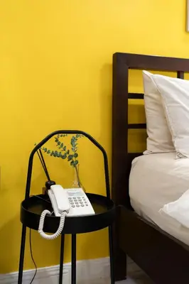 a phone sitting on a chair next to a bed at Greenbelt Makati Condo with Balcony & Park Views in Manila