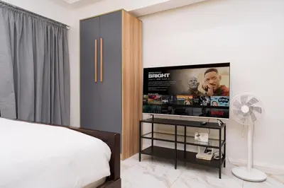 a bedroom with a bed and a flat screen tv at Greenbelt Makati Condo with Balcony & Park Views in Manila