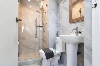 a bathroom with a toilet and a sink and a shower at Greenbelt Makati Condo with Balcony & Park Views in Manila