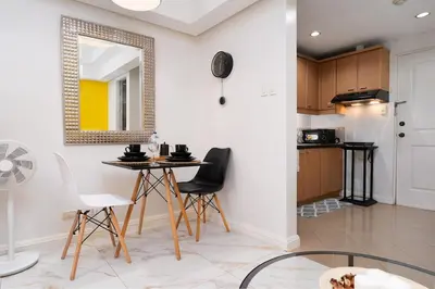 a kitchen and dining room with a table and chairs at Greenbelt Makati Condo with Balcony & Park Views in Manila