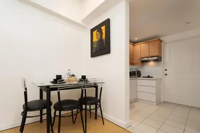 a kitchen with a table and chairs in a room at Comfy Greenbelt Suite - Fiber Wifi & Free Pool in Manila
