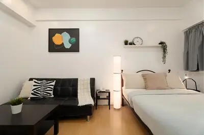 a living room with a bed and a couch at Comfy Greenbelt Suite - Fiber Wifi & Free Pool in Manila