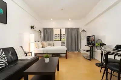 a living room with a bed and a couch at Comfy Greenbelt Suite - Fiber Wifi & Free Pool in Manila