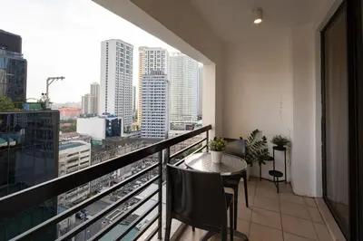 a balcony with a table and a view of a city at Comfy Greenbelt Suite - Fiber Wifi & Free Pool in Manila