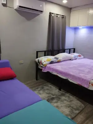 a bedroom with two beds with purple sheets and a fan at 40 Guest - Whole compound in Santa Rosa