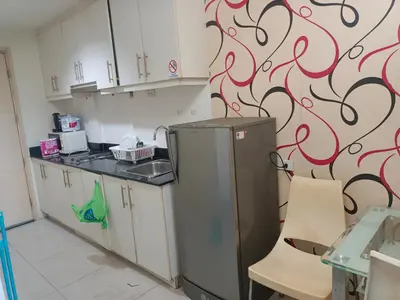 a kitchen with a refrigerator and a wall with swirls at Sea Residence Tower EF by Theresa P in Manila