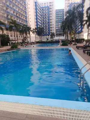 a large swimming pool in a city with tall buildings at Sea Residence Tower EF by Theresa P in Manila