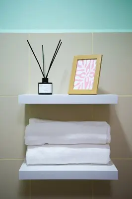 a shelf with white towels and a picture on it at Blush Haven with Netflix, WiFi and Balcony near Glorietta in Manila