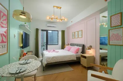 a bedroom with a bed and a table and chairs at Blush Haven with Netflix, WiFi and Balcony near Glorietta in Manila