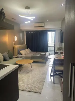 a living room with a bed and a couch at Studio for 4 with Netflix, 55in TV, 200Mbs net, in heart of Makati in Manila