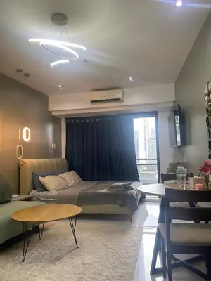 a living room with a bed and a couch at Studio for 4 with Netflix, 55in TV, 200Mbs net, in heart of Makati in Manila