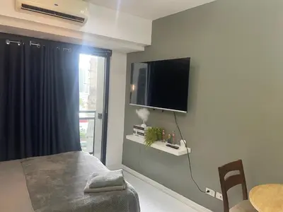 a bedroom with a flat screen tv on the wall at Studio for 4 with Netflix, 55in TV, 200Mbs net, in heart of Makati in Manila