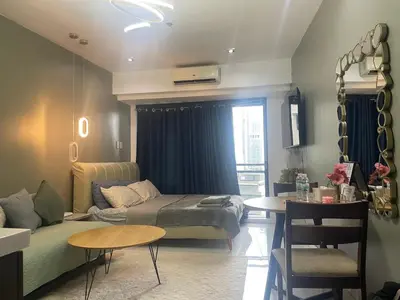 a living room with a couch and a table at Studio for 4 with Netflix, 55in TV, 200Mbs net, in heart of Makati in Manila