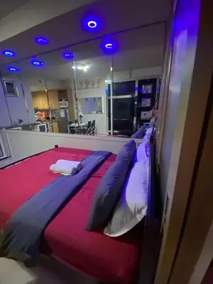 a large bed in a room with blue lights at 257-1BR 2 Queen size bed 1sofa bed 1 extra matress in Manila