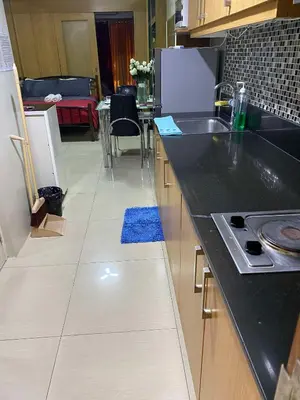 a kitchen with a black counter top and a blue rug at 257-1BR 2 Queen size bed 1sofa bed 1 extra matress in Manila
