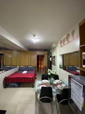 a room with a bed and a table with chairs at 257-1BR 2 Queen size bed 1sofa bed 1 extra matress in Manila