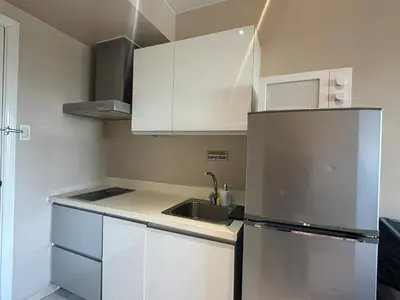 a small kitchen with white cabinets and a sink at Studio Unit with Balcony in The Gramercy Residences in Manila