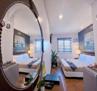 a room with two beds and a mirror in it at Collection O Avitel Hotel near Osmena Highway, PNR Pasay Station, Metro Manila in Manila