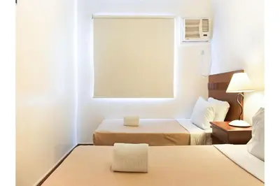 a hotel room with two beds and a window at Collection O Avitel Hotel near Osmena Highway, PNR Pasay Station, Metro Manila in Manila