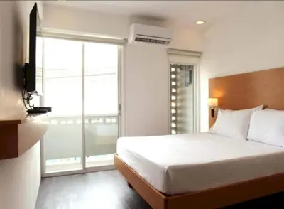a bedroom with a bed and a large window at Collection O Avitel Hotel near Osmena Highway, PNR Pasay Station, Metro Manila in Manila