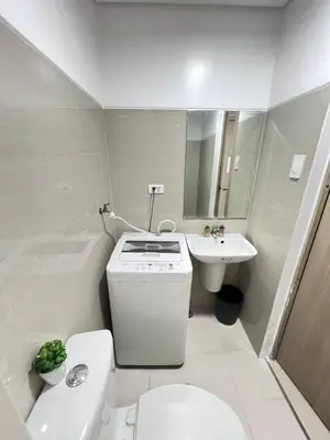 a white bathroom with a toilet and a sink at Unistay Shore Res with Bal Manila Bay View nr MOA in Manila