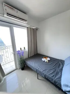 a bedroom with a bed with a tray on it at Unistay Shore Res with Bal Manila Bay View nr MOA in Manila