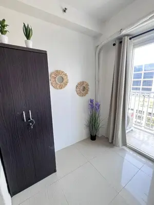 a room with a wooden door and a window at Unistay Shore Res with Bal Manila Bay View nr MOA in Manila