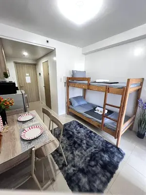 a living room with a table and a bunk bed at Unistay Shore Res with Bal Manila Bay View nr MOA in Manila