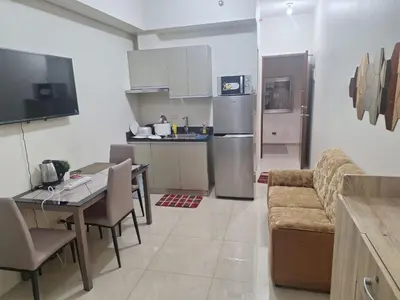 a kitchen and living room with a couch and a table at Chelsea Suites at the Beacon Makati in Manila