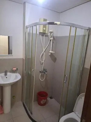 a bathroom with a shower and a sink at Chelsea Suites at the Beacon Makati in Manila
